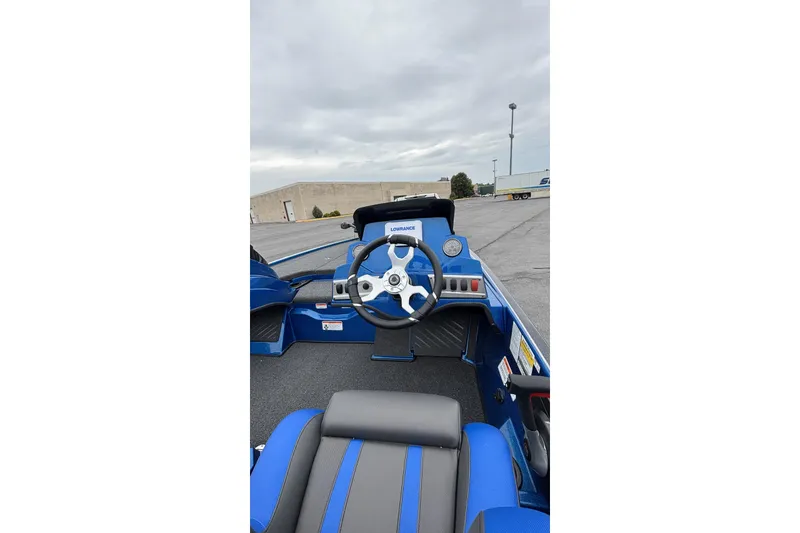 The Image of 2026 Nitro Z19 XL boat interior with steering wheel and dashboard, parked outdoors. - 0