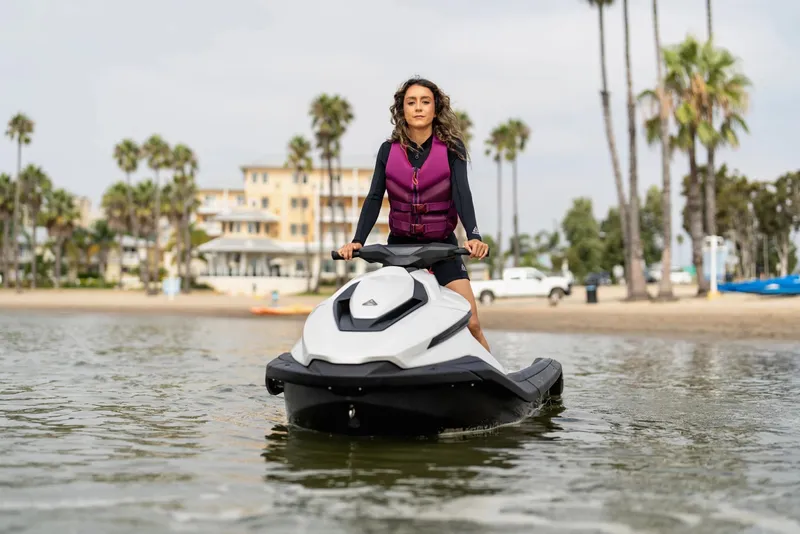 Slide: The Image of Person riding 2025 Taiga Orca P2 jet ski near a beach with palm trees. - 1