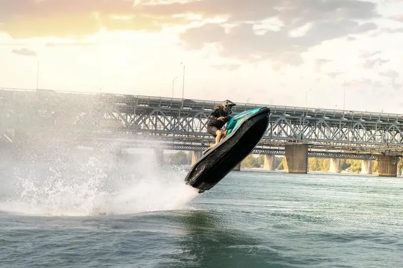 Slide: The Image of Person riding 2025 Taiga Orca P2 jet ski, jumping over water near a bridge. - 12