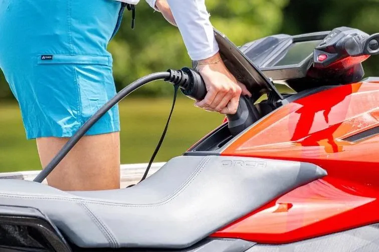 Slide: The Image of Charging a 2025 Taiga Orca P2 electric watercraft in a scenic outdoor setting. - 13