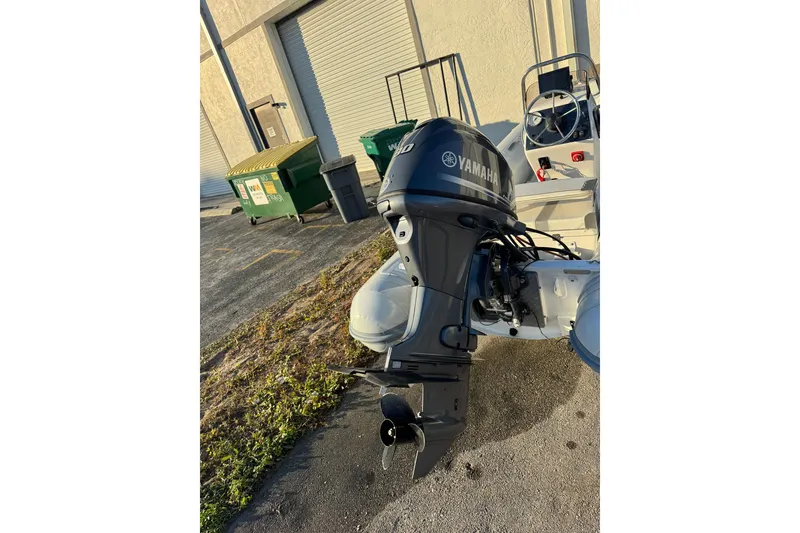 Slide: The Image of 2022 AB Inflatables Alumina 11 ALX with Yamaha outboard motor, parked near dumpsters. - 6