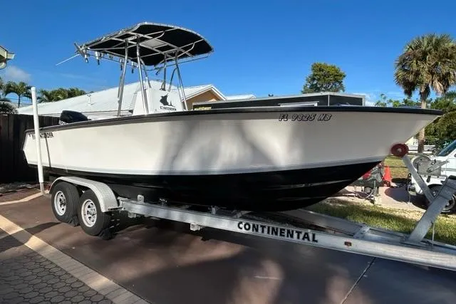 The Image of 2006 Contender 21 Open boat on trailer, parked outdoors under clear blue sky. - 0