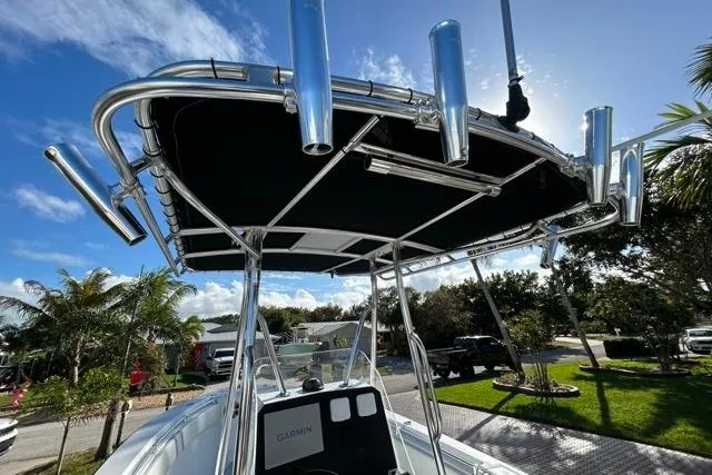 Slide: The Image of 2006 Contender 21 Open boat with T-top and rod holders under a sunny sky. - 13