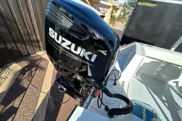 Slide: The Image of 2006 Contender 21 Open boat with Suzuki outboard motor in a sunny setting. - 20