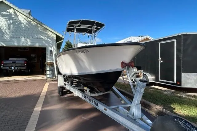 Slide: The Image of 2006 Contender 21 Open boat on trailer, parked in driveway under clear blue sky. - 27
