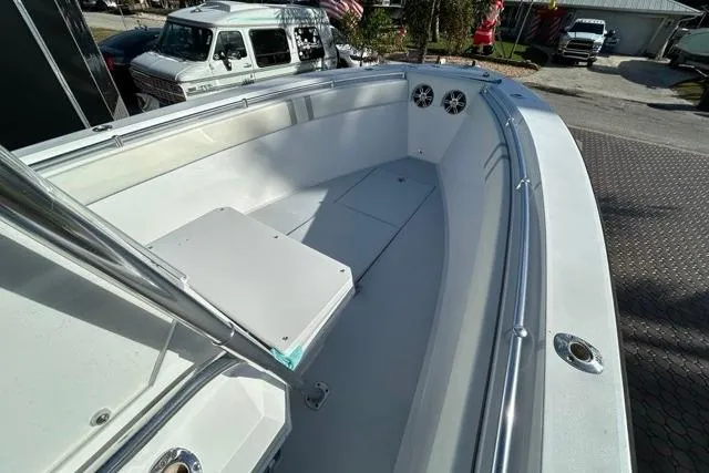 Slide: The Image of 2006 Contender 21 Open boat interior with seating and speakers, parked outdoors. - 7