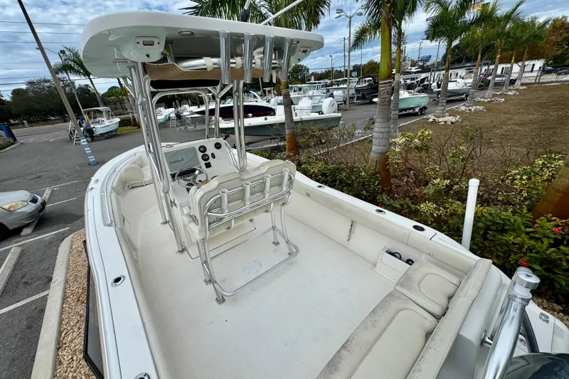 Slide: The Image of 2019 Key West 239 FS boat interior with console and seating, parked in a marina. - 11