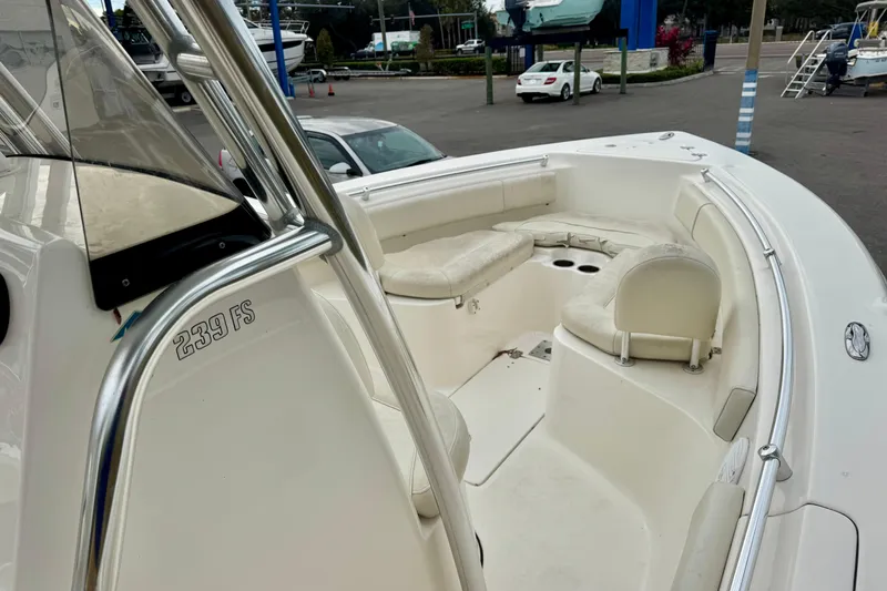 Slide: The Image of 2019 Key West 239 FS boat with T-top, parked near palm trees and vehicles. - 20