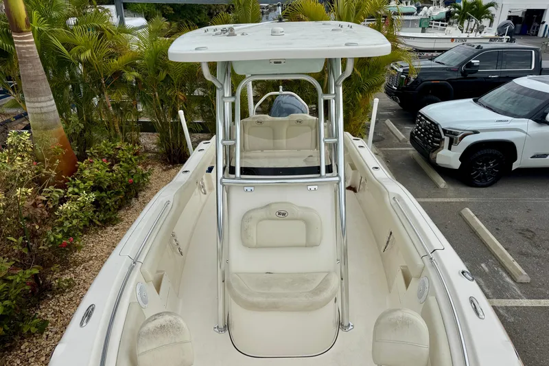 Slide: The Image of 2019 Key West 239 FS boat with white cushioned seating and tropical background. - 23