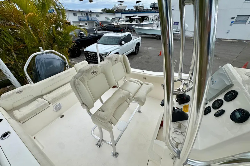 Slide: The Image of 2019 Key West 239 FS boat interior with seating and cup holders, parked near vehicles. - 26