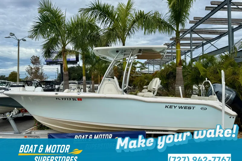 Slide: The Image of 2019 Key West 239 FS boat with T-top, parked outdoors in a sunny setting. - 30