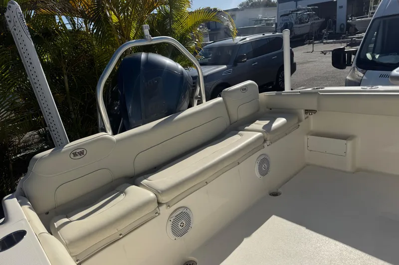 Slide: The Image of 2019 Key West 239 FS boat interior with seating and motor, parked outdoors. - 35