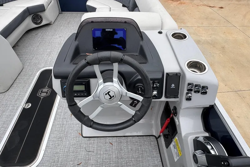 Slide: The Image of 2025 Harris Sunliner 230 boat dashboard with steering wheel and control panel. - 5