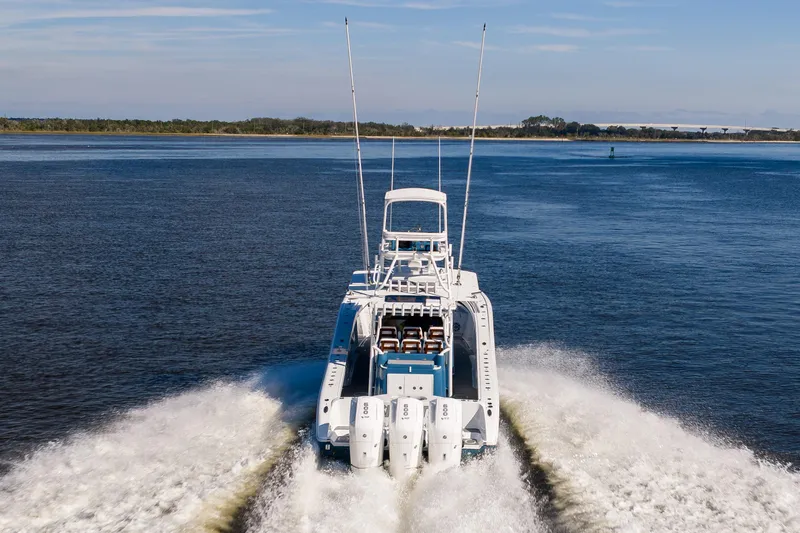 Slide: The Image of 2024 Yellowfin 42 Offshore boat cruising on open water, rear view. - 11