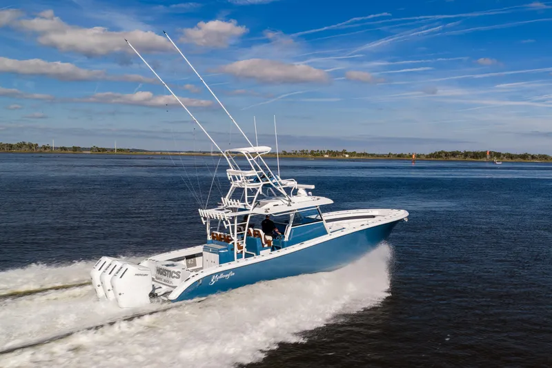 Slide: The Image of 2024 Yellowfin 42 Offshore boat cruising on open water under a blue sky. - 12