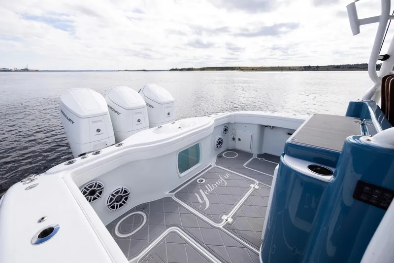 Slide: The Image of 2024 Yellowfin 42 Offshore boat with triple Mercury engines on calm water. - 18