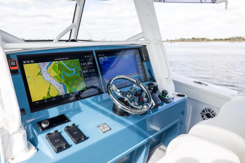 Slide: The Image of 2024 Yellowfin 42 Offshore boat dashboard with navigation screens and steering wheel. - 32