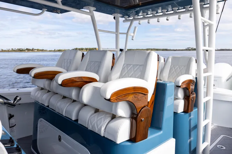 Slide: The Image of 2024 Yellowfin 42 Offshore boat with luxurious white and wood seating, ocean backdrop. - 39