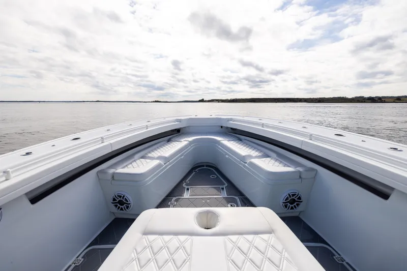 Slide: The Image of 2024 Yellowfin 42 Offshore boat interior with cushioned seating and ocean view. - 51