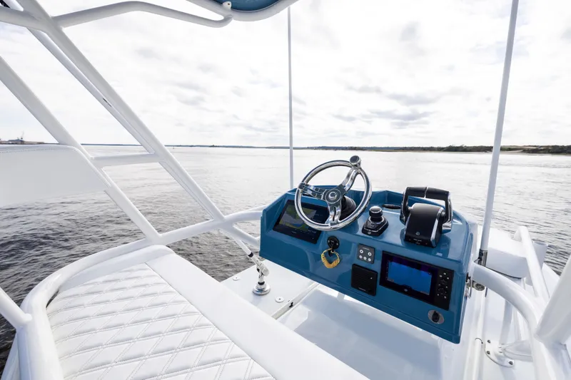 Slide: The Image of 2024 Yellowfin 42 Offshore boat helm with steering wheel and navigation controls. - 56