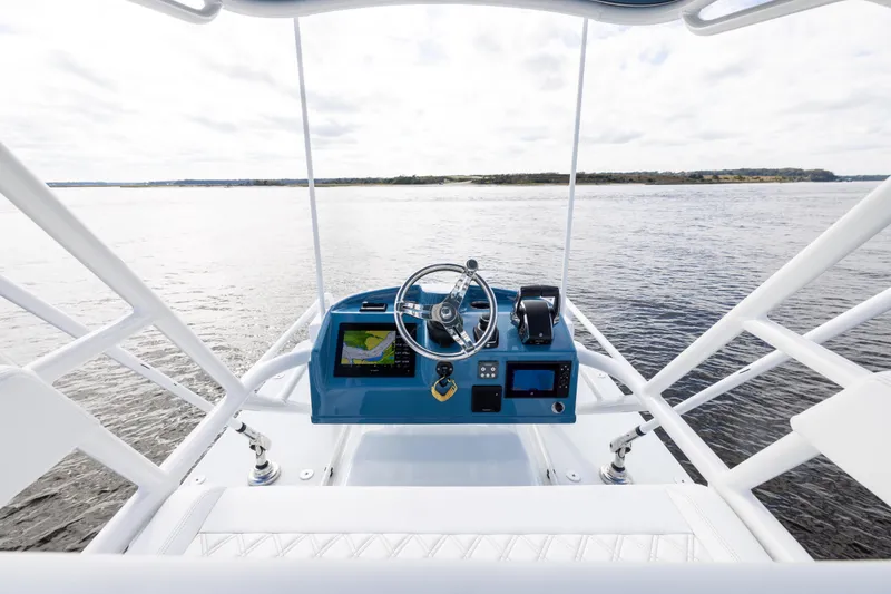 Slide: The Image of 2024 Yellowfin 42 Offshore boat helm with navigation screens on open water. - 57