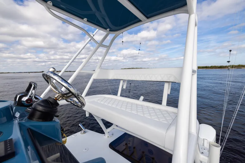 Slide: The Image of 2024 Yellowfin 42 Offshore boat helm with white seating and ocean view. - 62