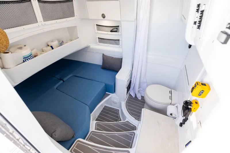 Slide: The Image of 2024 Yellowfin 42 Offshore cabin interior with bed, toilet, and storage shelves. - 67