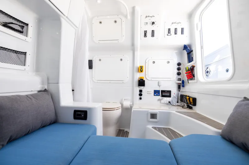 Slide: The Image of 2024 Yellowfin 42 Offshore cabin interior with blue seating and control panels. - 68