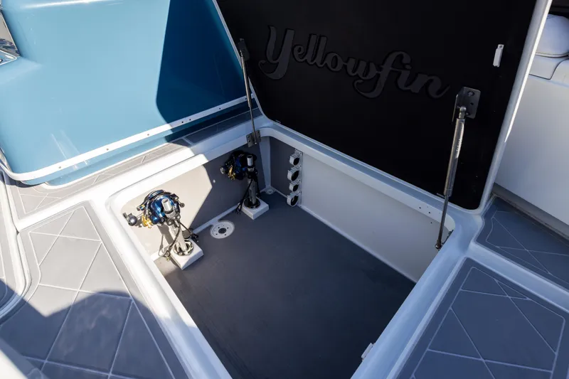 Slide: The Image of 2024 Yellowfin 42 Offshore boat storage compartment with open hatch and fishing equipment. - 72