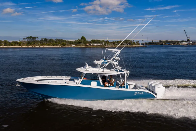 Slide: The Image of 2024 Yellowfin 42 Offshore boat cruising on a sunny day, showcasing sleek design and powerful engines. - 9