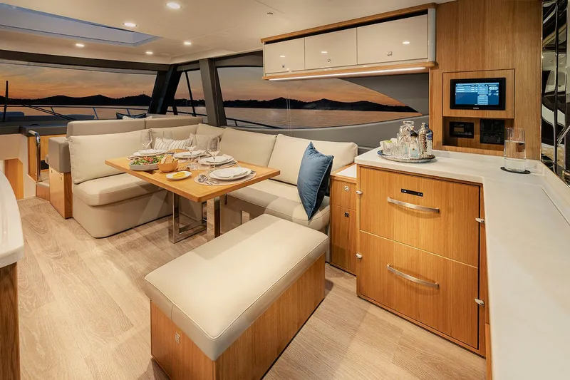 Slide: The Image of Manufacturer Provided Image: Luxurious interior of 2025 Riviera 585 SUV yacht with elegant dining area and sunset view. - 12