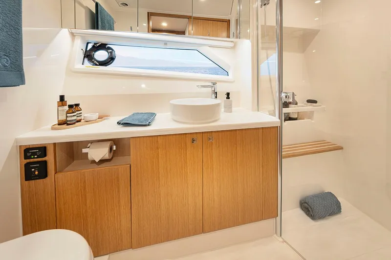 Slide: The Image of Manufacturer Provided Image: Luxurious bathroom in 2025 Riviera 585 SUV yacht with modern fixtures and wooden cabinetry. - 18