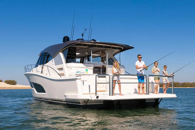 Slide: The Image of Manufacturer Provided Image: 2025 Riviera 585 SUV yacht with people fishing on deck in sunny waters. - 5