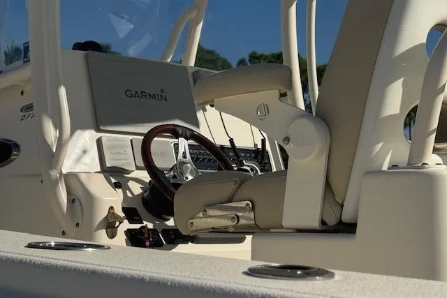 Slide: The Image of 2016 Cobia 277 Center Console boat interior with Garmin equipment and steering wheel. - 12