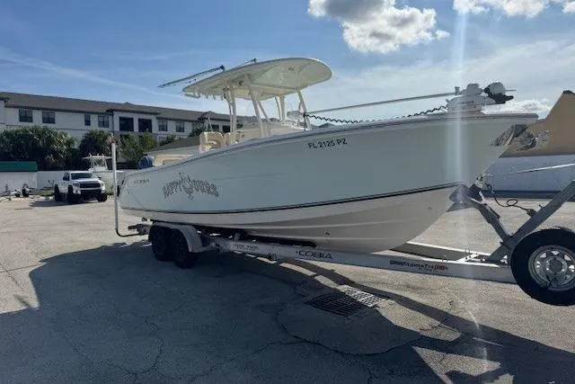 Slide: The Image of 2016 Cobia 277 Center Console boat on trailer in sunny parking lot. - 2