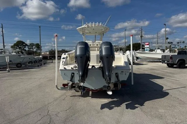 Slide: The Image of 2016 Cobia 277 Center Console boat with dual outboard engines in a sunny marina. - 4