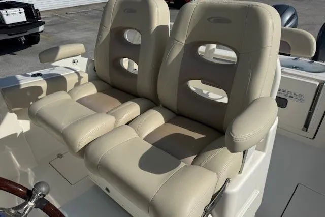 Slide: The Image of 2016 Cobia 277 Center Console boat with beige cushioned seats. - 5