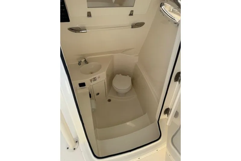 Slide: The Image of 2016 Cobia 277 Center Console boat interior with compact bathroom amenities. - 6