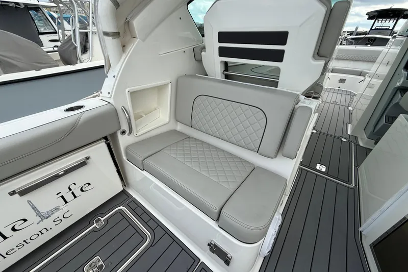 Slide: The Image of 2023 Pursuit DC 326 Dual Console boat interior with gray seating and sleek design. - 14