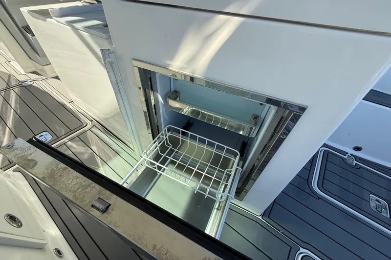 Slide: The Image of Open storage compartment on 2023 Pursuit DC 326 Dual Console boat deck. - 17