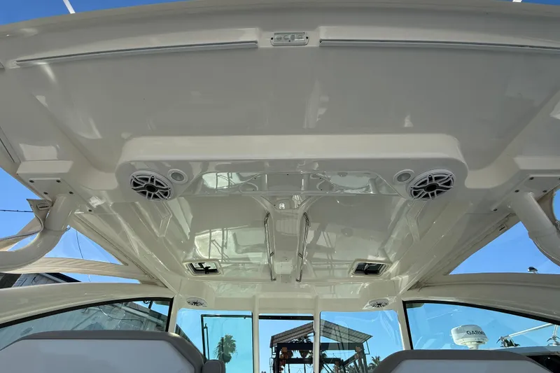 Slide: The Image of 2023 Pursuit DC 326 Dual Console boat interior with speakers and sleek design. - 19