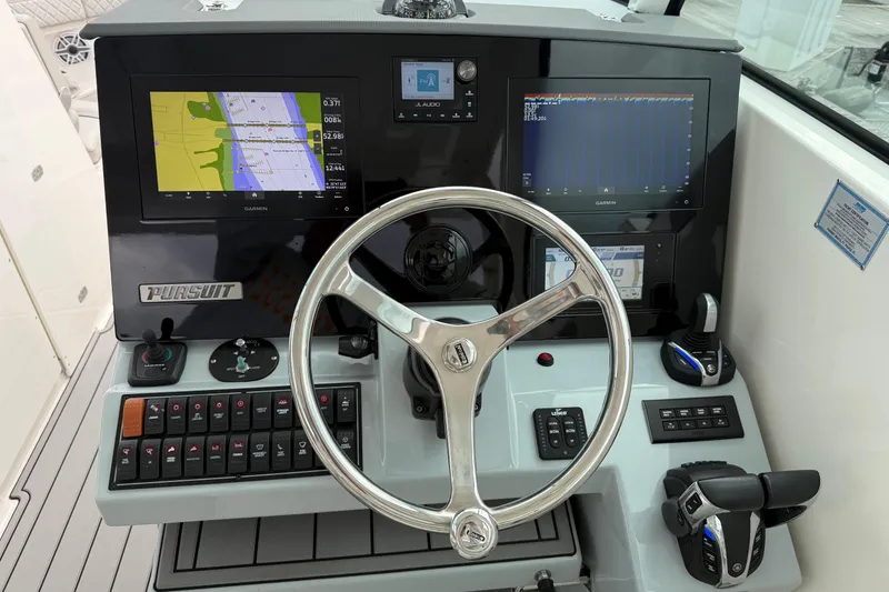 Slide: The Image of 2023 Pursuit DC 326 Dual Console boat dashboard with Garmin navigation displays and controls. - 24