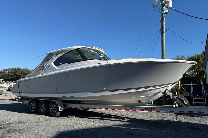 Slide: The Image of 2023 Pursuit DC 326 Dual Console boat on trailer under clear blue sky. - 41