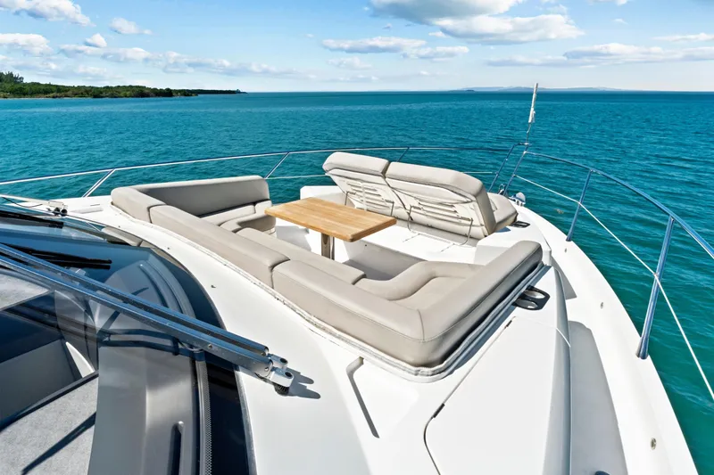 Slide: The Image of Luxurious Sunseeker Manhattan 66 yacht deck with seating, 2019 model, on serene blue waters. - 10