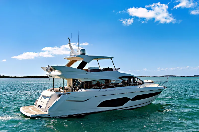 Slide: The Image of 2019 Sunseeker Manhattan 66 yacht cruising on clear blue waters under a sunny sky. - 4