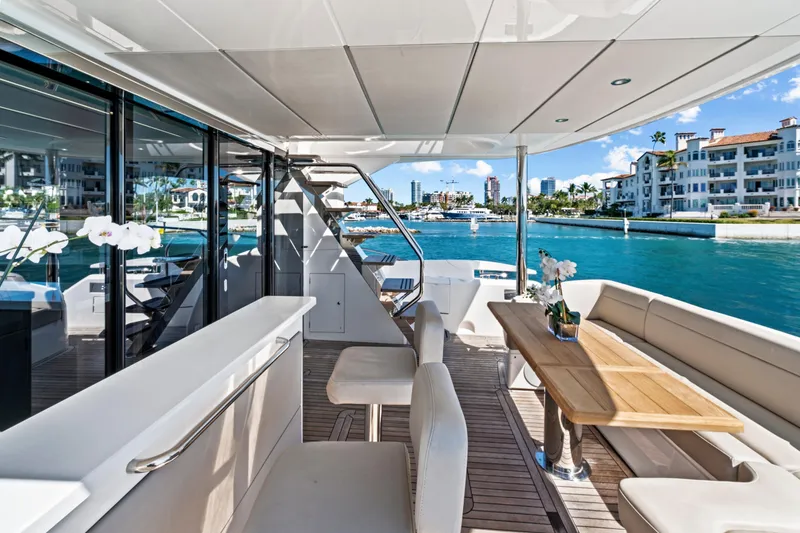 Slide: The Image of Luxurious 2019 Sunseeker Manhattan 66 yacht deck with elegant seating and waterfront view. - 7