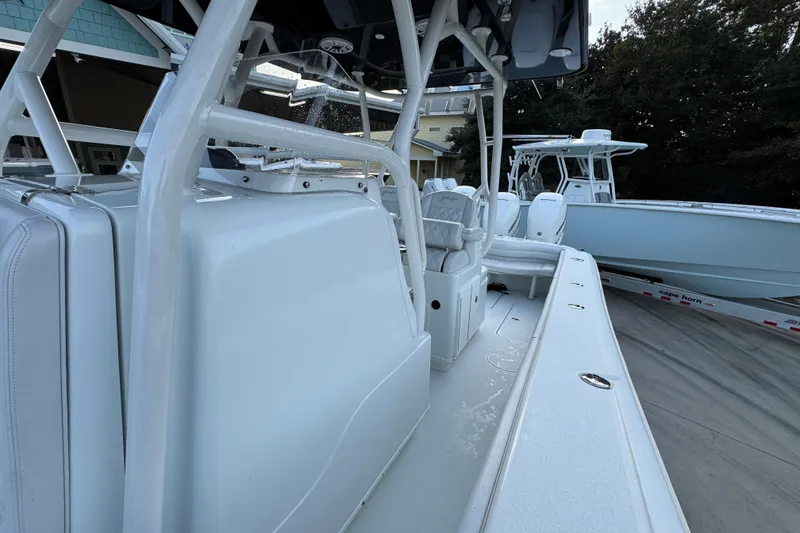 Slide: The Image of 2019 Yellowfin 34 Offshore boat interior with seating and console, docked outdoors. - 23
