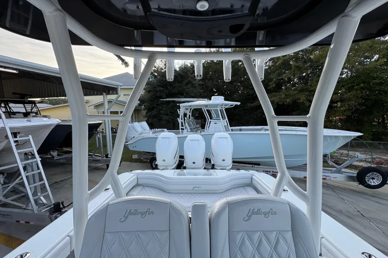 Slide: The Image of 2019 Yellowfin 34 Offshore boat with triple engines, docked in a marina setting. - 27