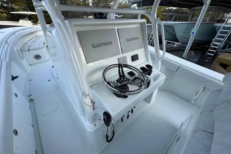 Slide: The Image of 2019 Yellowfin 34 Offshore boat cockpit with Garmin navigation system and steering wheel. - 28