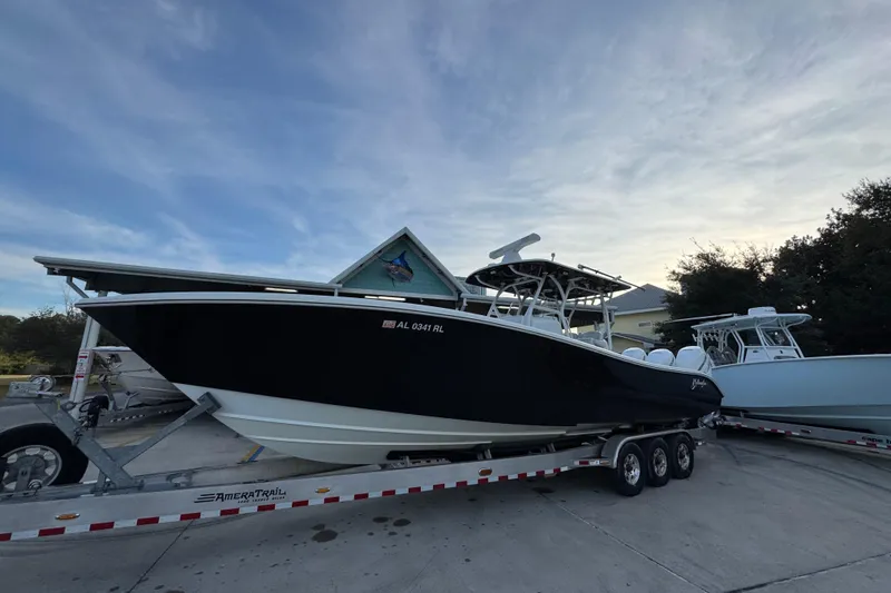 Slide: The Image of 2019 Yellowfin 34 Offshore boat on trailer, parked outdoors under a cloudy sky. - 3